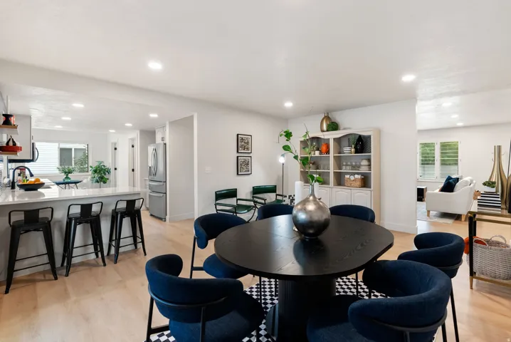 Light wood-finish flooring throughout, recessed lighting, and a kitchen island with stone countertop