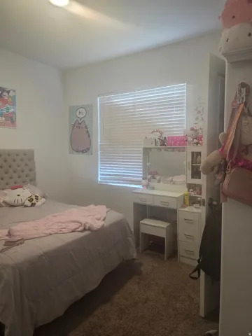 Recessed lighting illuminates this room featuring wall-to-wall carpeting and a window with horizontal blinds