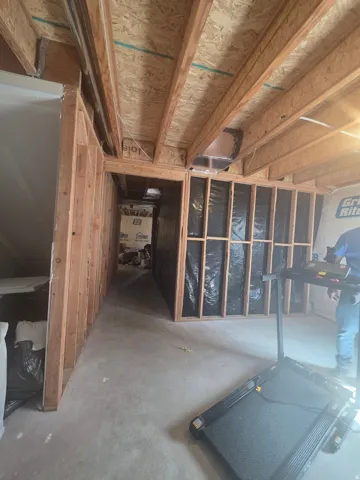 Unfinished basement space with exposed wooden joists and framing