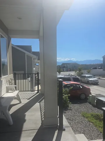 Front porch with a concrete surface, featuring a railing system and a visible distant mountain range