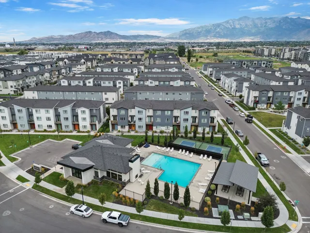 Community features a central swimming pool, paved pool deck, shaded outdoor seating, and tennis courts