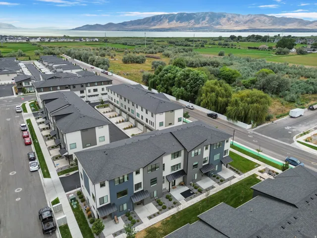 Modern multi-story townhomes with dark gray roofs and contrasting facades