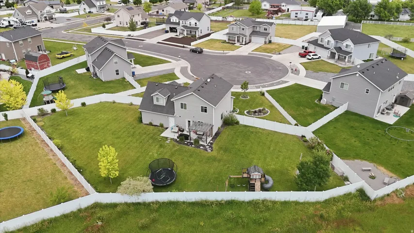 Spacious lot featuring a manicured lawn, established landscaping, and a privacy fence