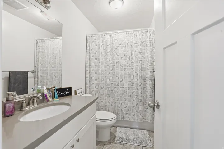 Vanity with integrated sink, brushed nickel faucet, and a large wall mirror