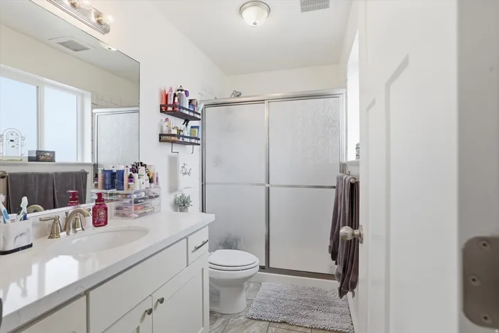 White vanity with a single basin sink, brushed nickel faucet, and integrated countertop
