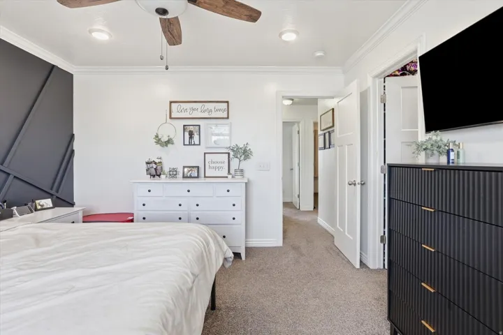 Ceiling fan with wood-finish blades, recessed lighting, crown molding, and carpeted flooring