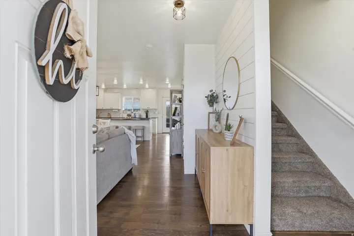 Wood-finish flooring, recessed lighting, white shiplap accent wall, staircase with carpeted treads