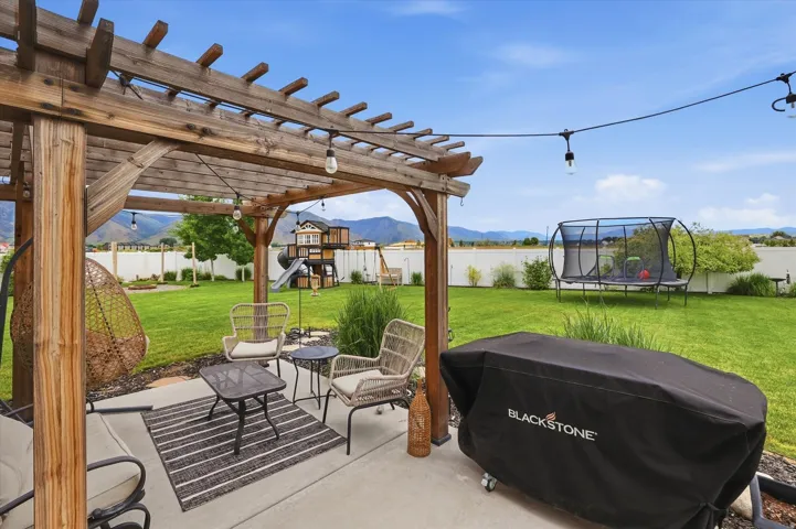 Wood pergola with string lighting and concrete patio