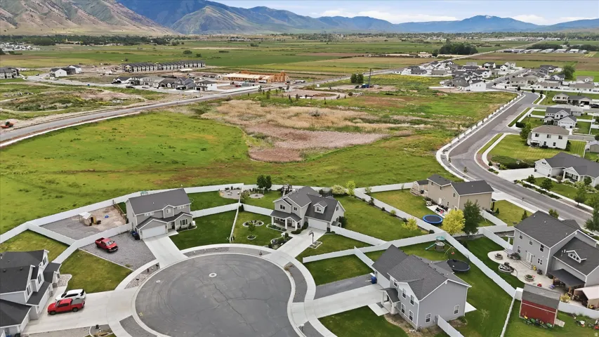 Cul-de-sac properties featuring gray exteriors, white fencing, and integrated garages, surrounded by green landscaping