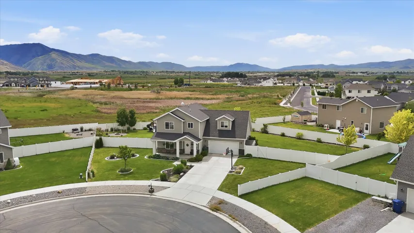 Two-story residence with an attached garage, paved driveway, and established front landscaping