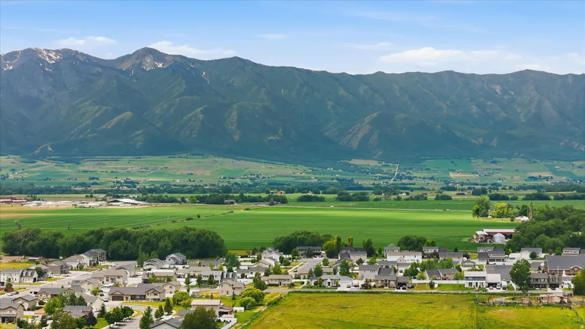 Neighborhood setting with mountain backdrop and expansive green fields