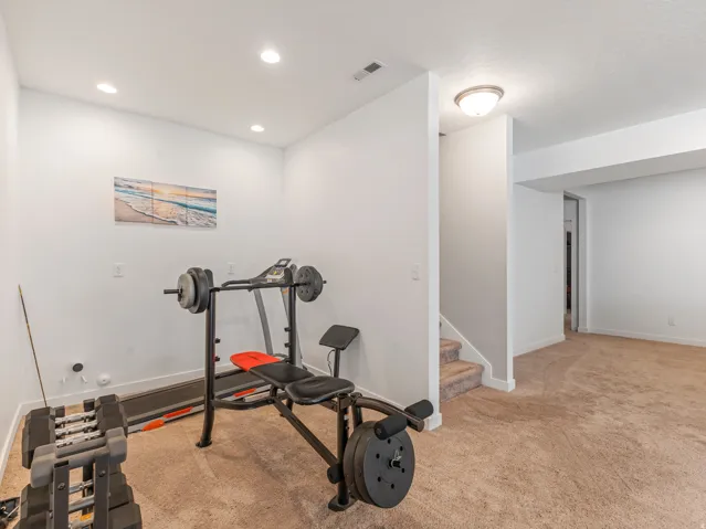 Carpeted room with recessed lighting and a flush-mount ceiling fixture