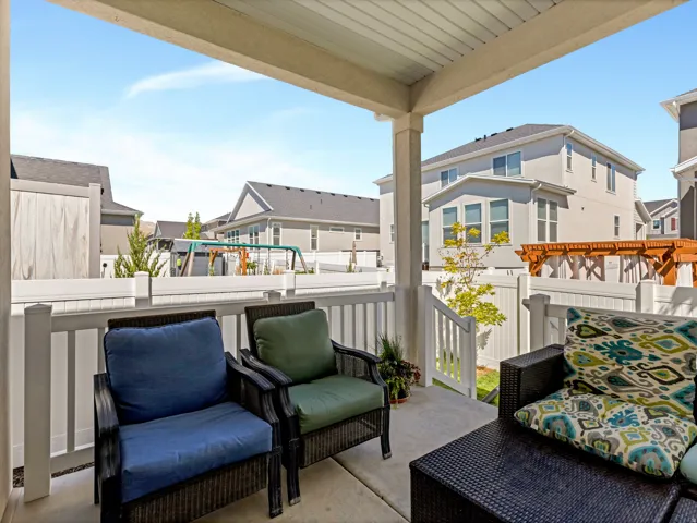 Covered patio featuring a concrete slab and white railing