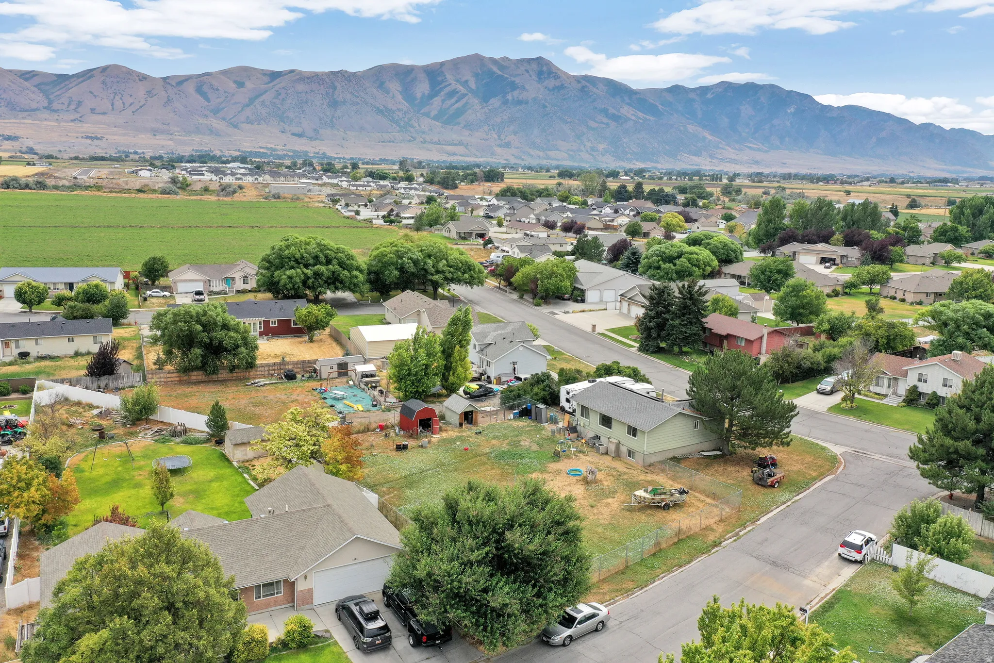 Mountain backdrop and neighborhood setting with residential properties and cultivated fields