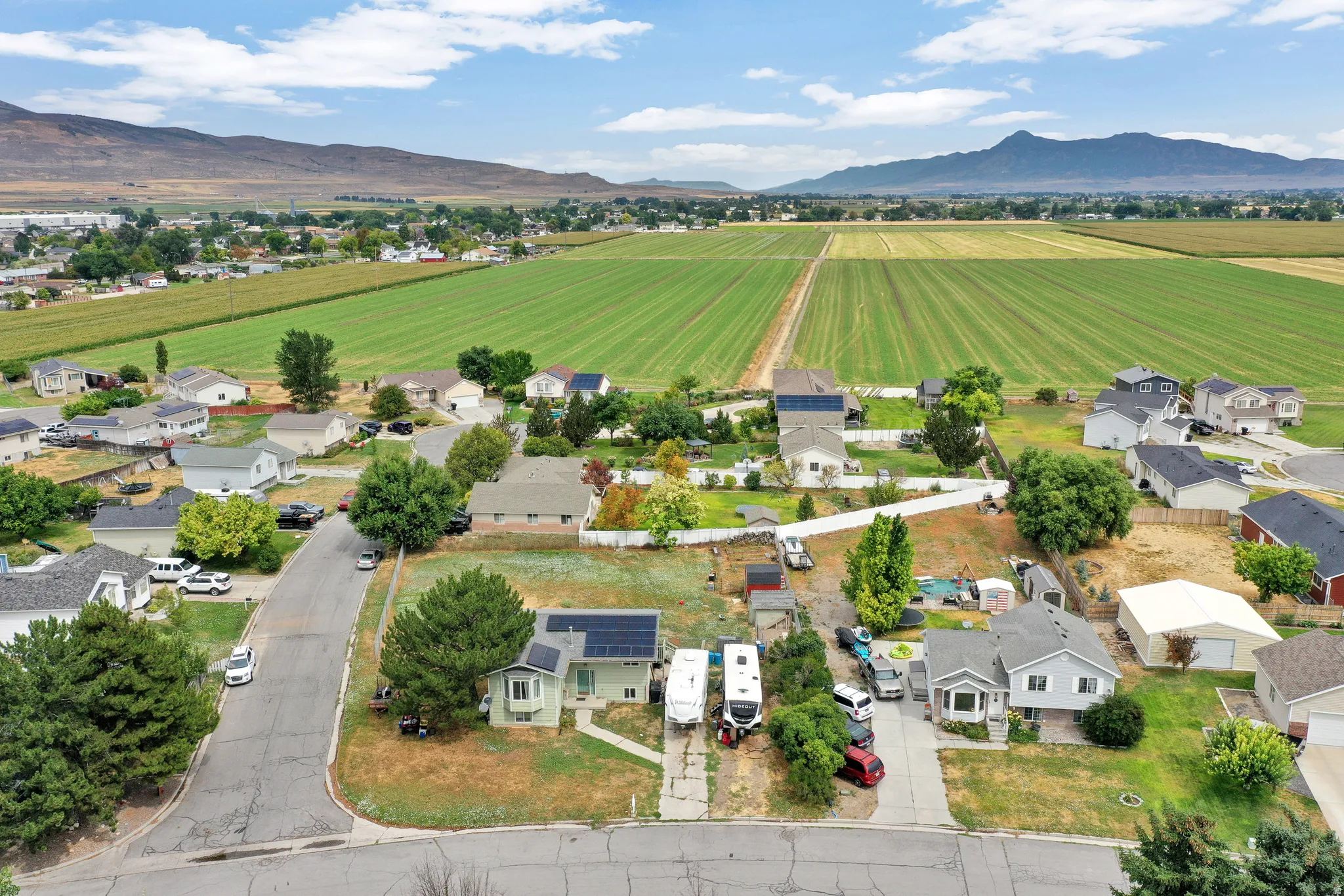 Residential neighborhood with open fields and distant mountains