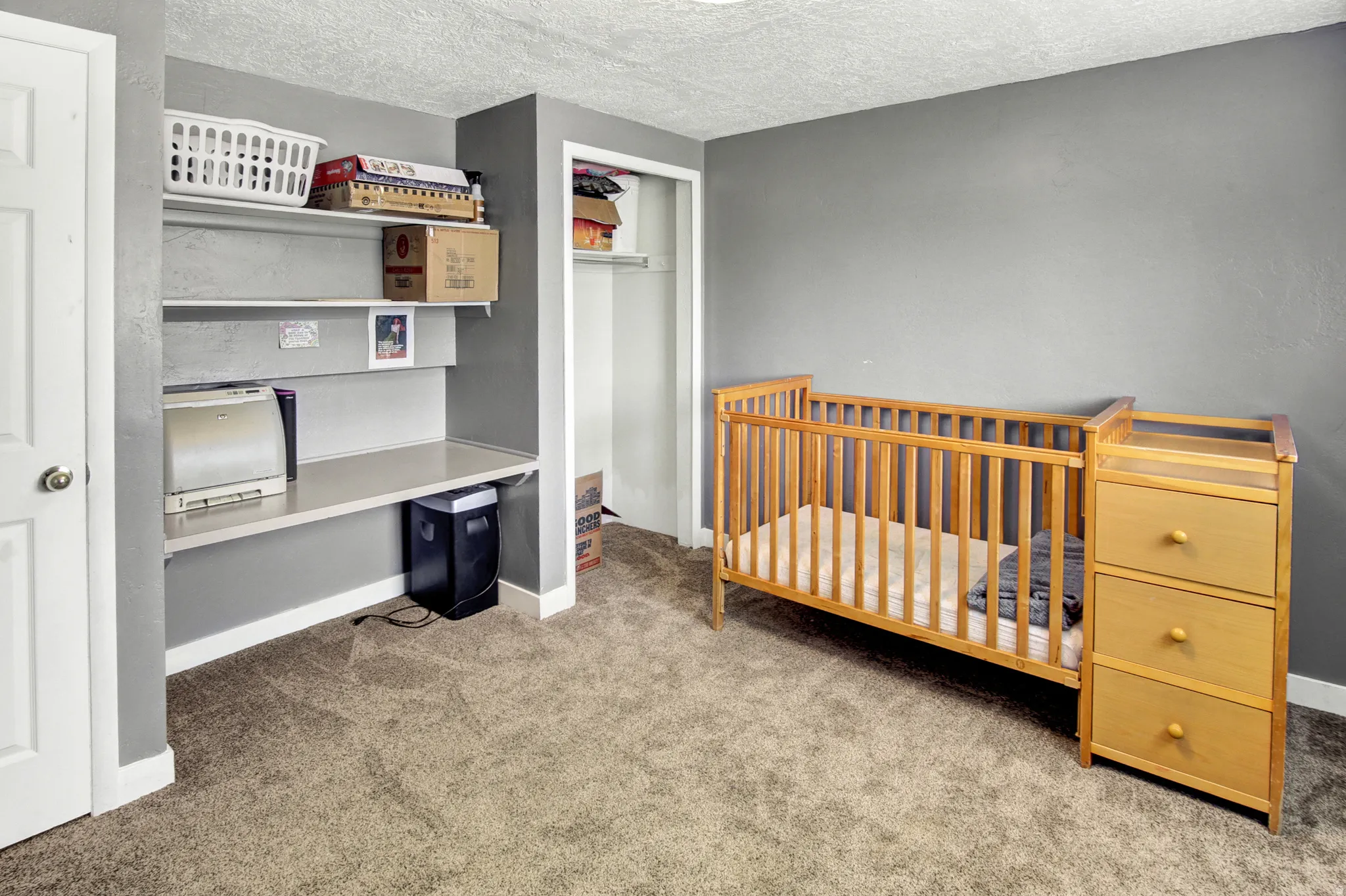 Built-in shelving, integrated desk surface, and neutral carpeting