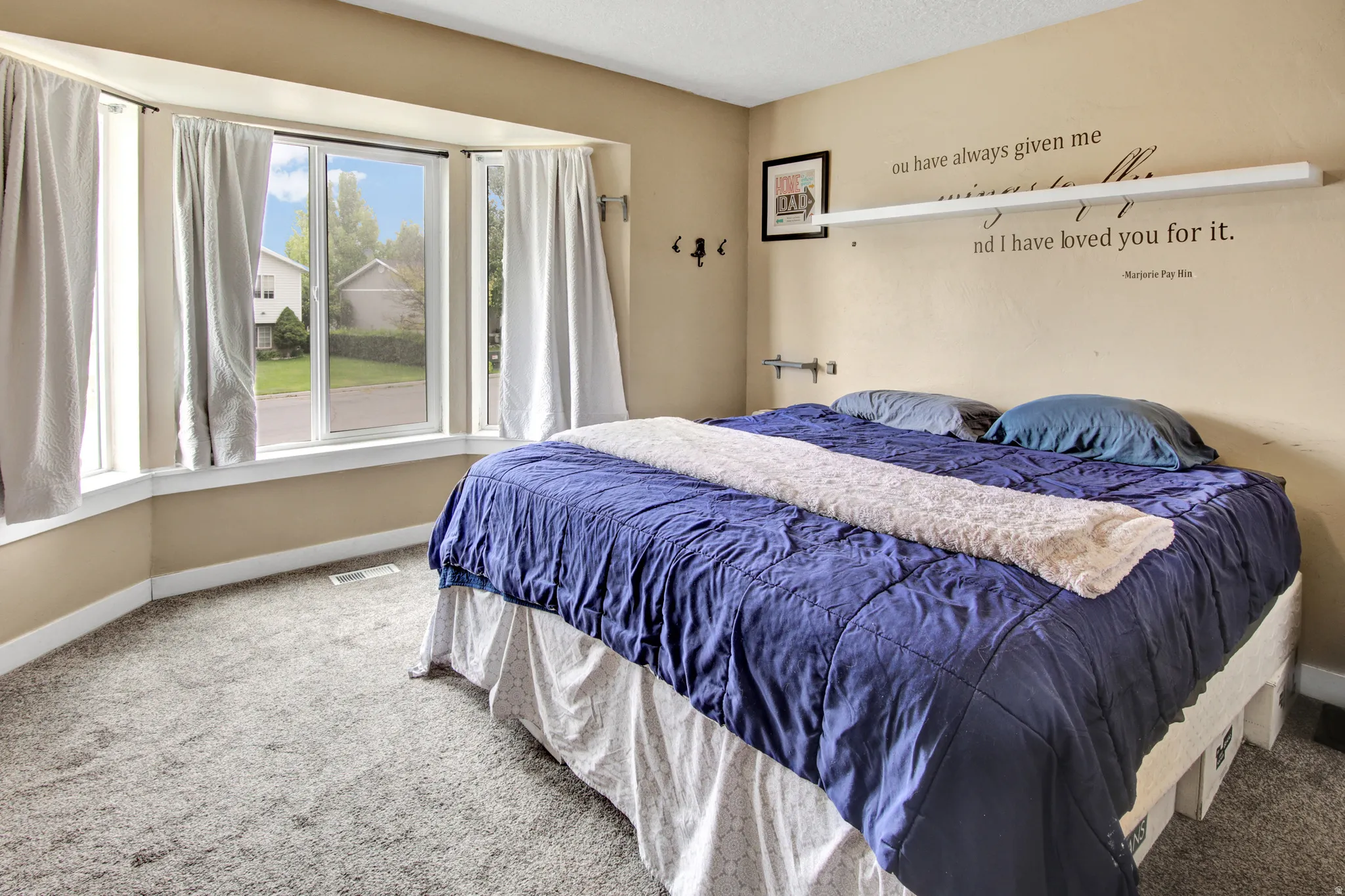Bay window with white trim, wall-to-wall carpeting, and neutral paint