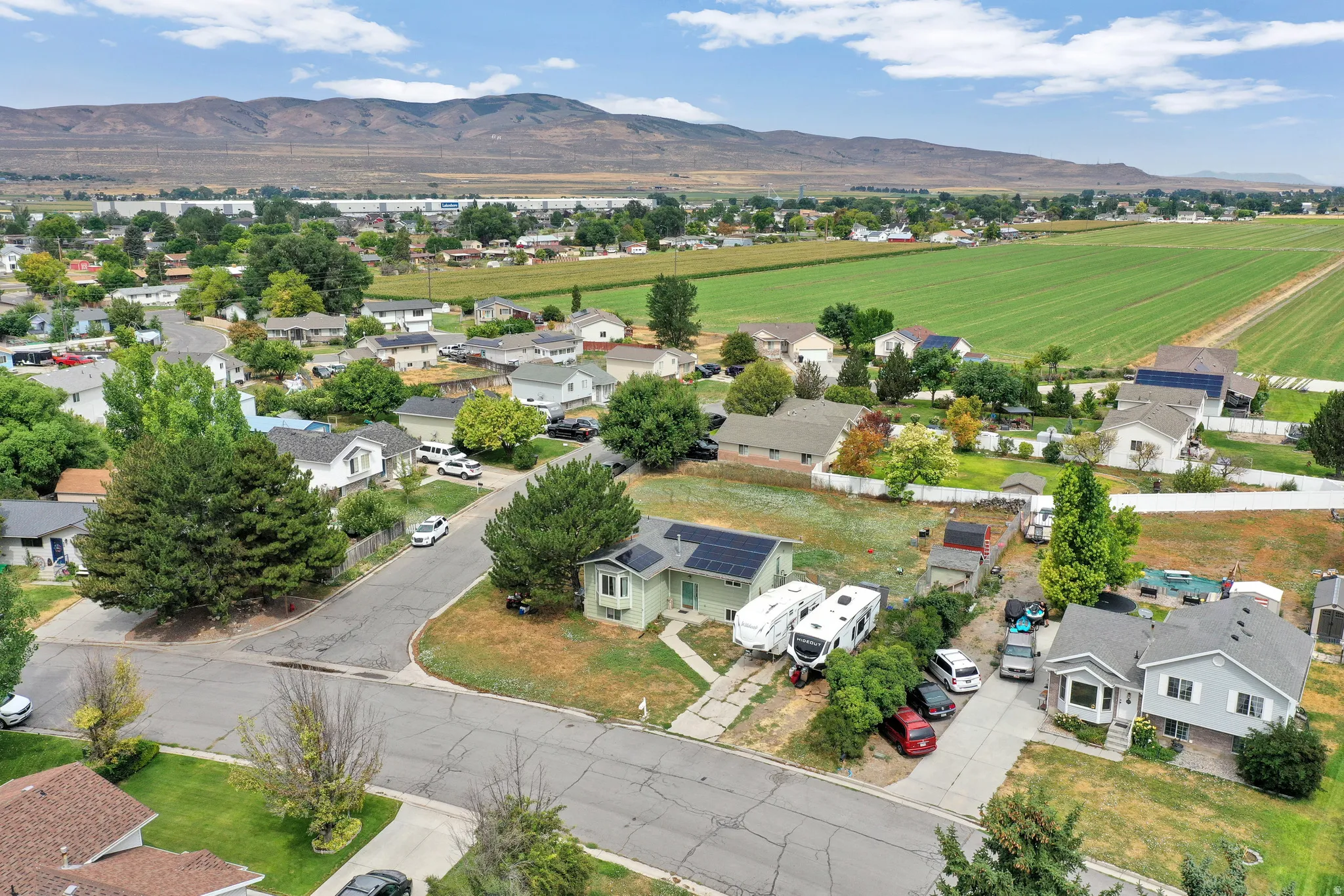 Residential neighborhood setting with agricultural fields and distant mountains