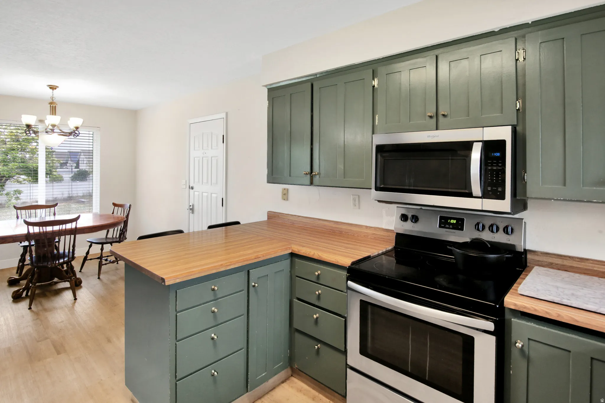 Kitchen featuring painted cabinetry, wood-finish countertops, and stainless-steel appliances