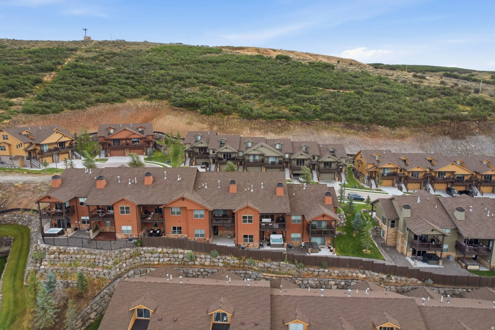 Townhome development featuring multiple stories, private balconies, and stone retaining walls