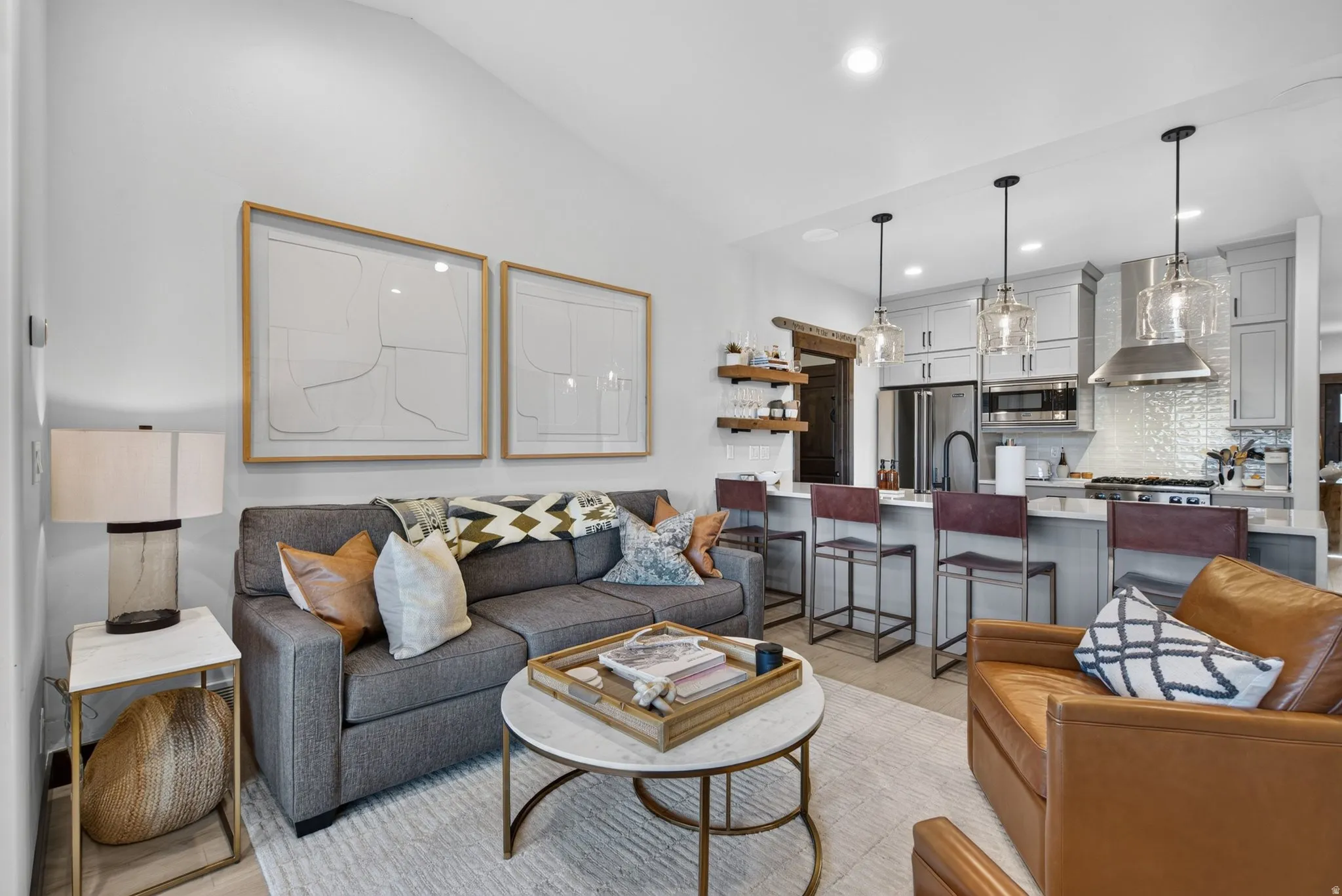 Vaulted ceiling, recessed lighting, and wood-finish flooring in the living area