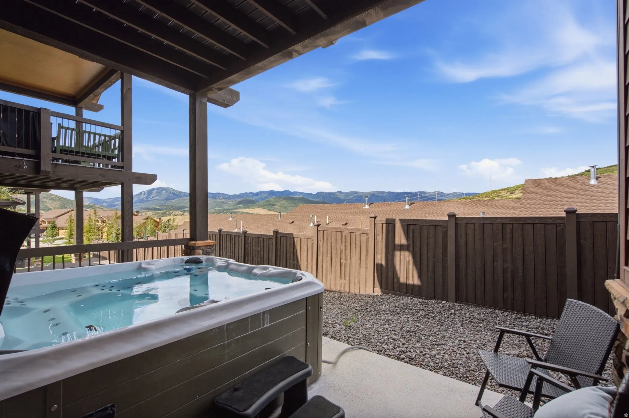 Private patio featuring an integrated hot tub and durable wood fencing