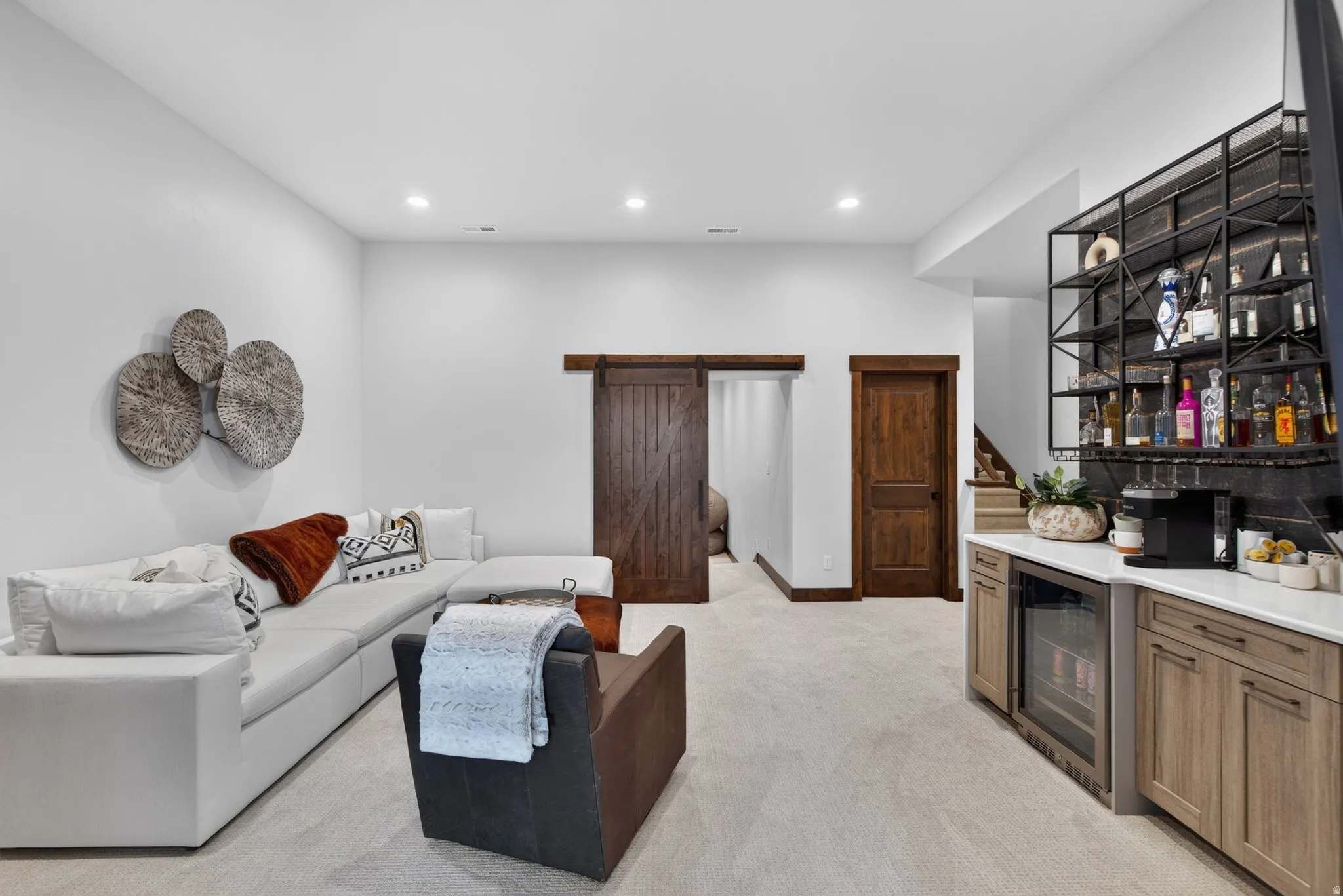 Built-in wet bar with wood-finish cabinetry, under-counter beverage refrigerator, and open shelving