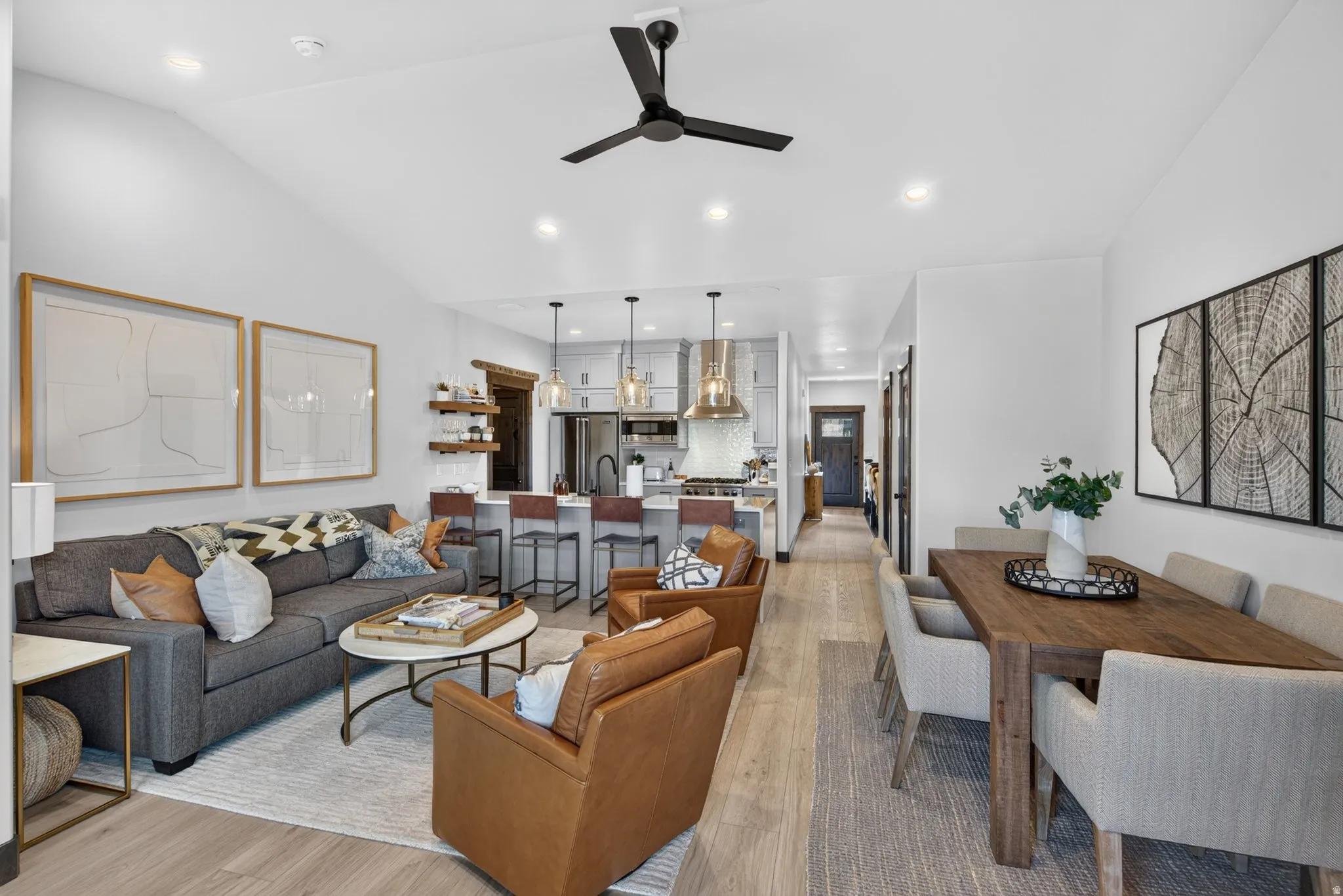 Vaulted ceiling, recessed lighting, wood-finish flooring, kitchen island with seating, pendant lighting