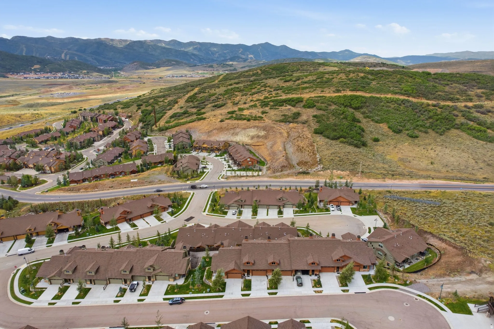 Mountain setting with residential community, paved roadways, and surrounding natural landscape