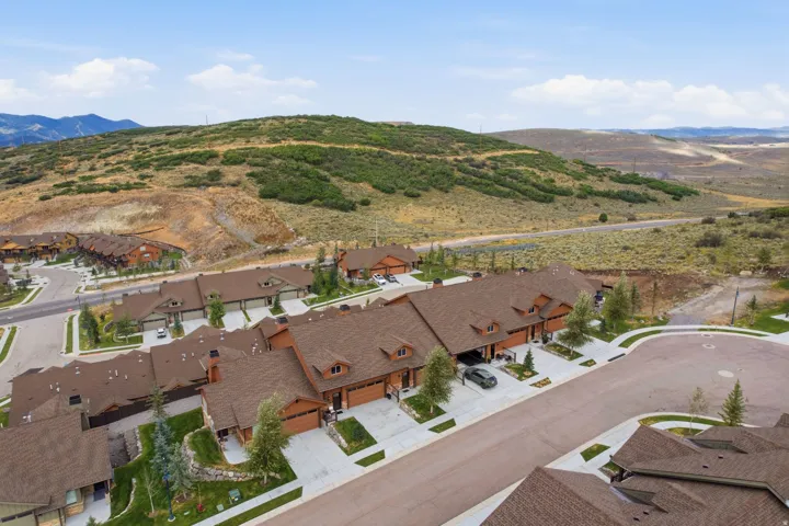 Aerial perspective showcasing a residential development with multiple units, each featuring a pitched roof and attached garage