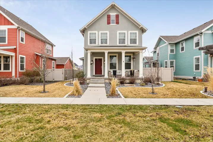 Two-story exterior with a covered porch, column supports, front door with sidelights, and a walkway leading to a multi-tiered entry