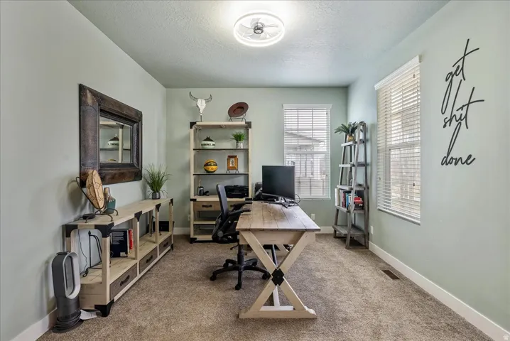 Recessed lighting, light-toned walls, and a window with blinds provide illumination