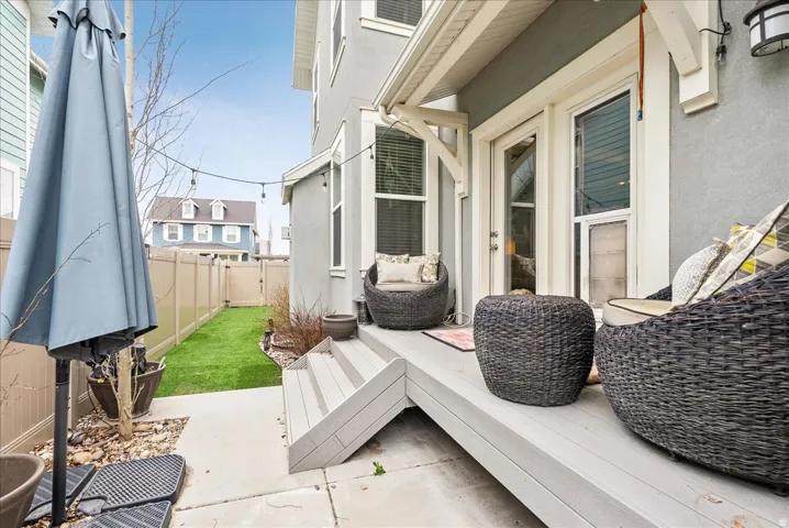Deck with composite flooring, dual French patio doors, and string lighting