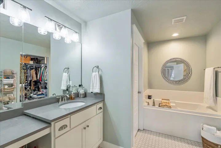 Integrated vanity with a single basin, recessed lighting, and a built-in soaking tub