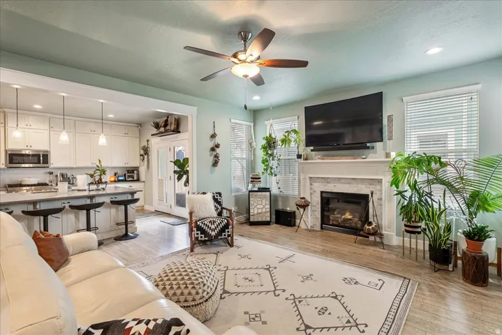 Open concept living area featuring wood-finish flooring, a ceiling fan, and recessed lighting