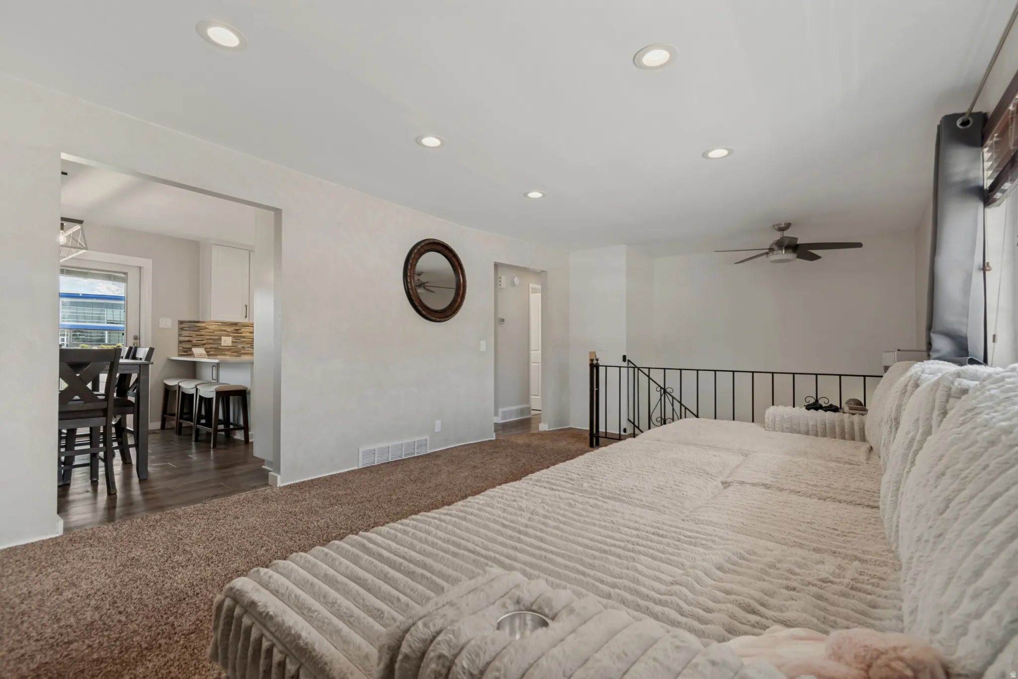 Recessed lighting, ceiling fan, carpet flooring, open archway, and iron railing