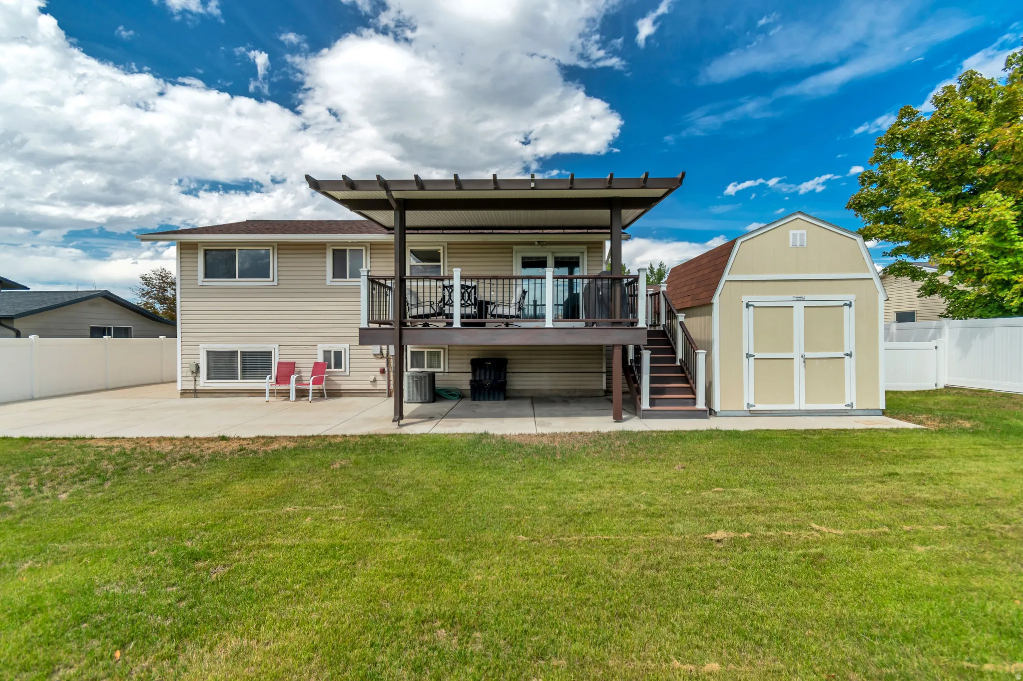 Expansive grassy yard with a concrete patio