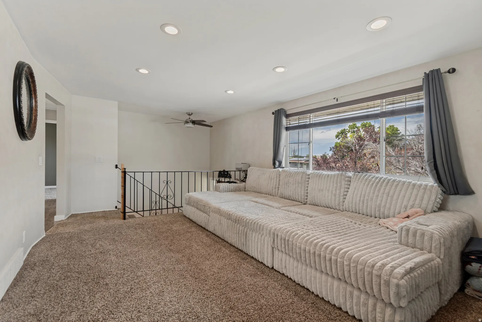 Carpeted room featuring recessed lighting, a ceiling fan, and a large window