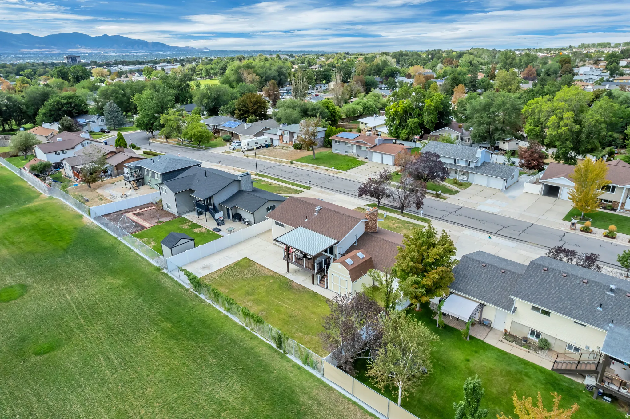 Expansive residential neighborhood featuring paved streets and established homes, set against a distant mountain backdrop