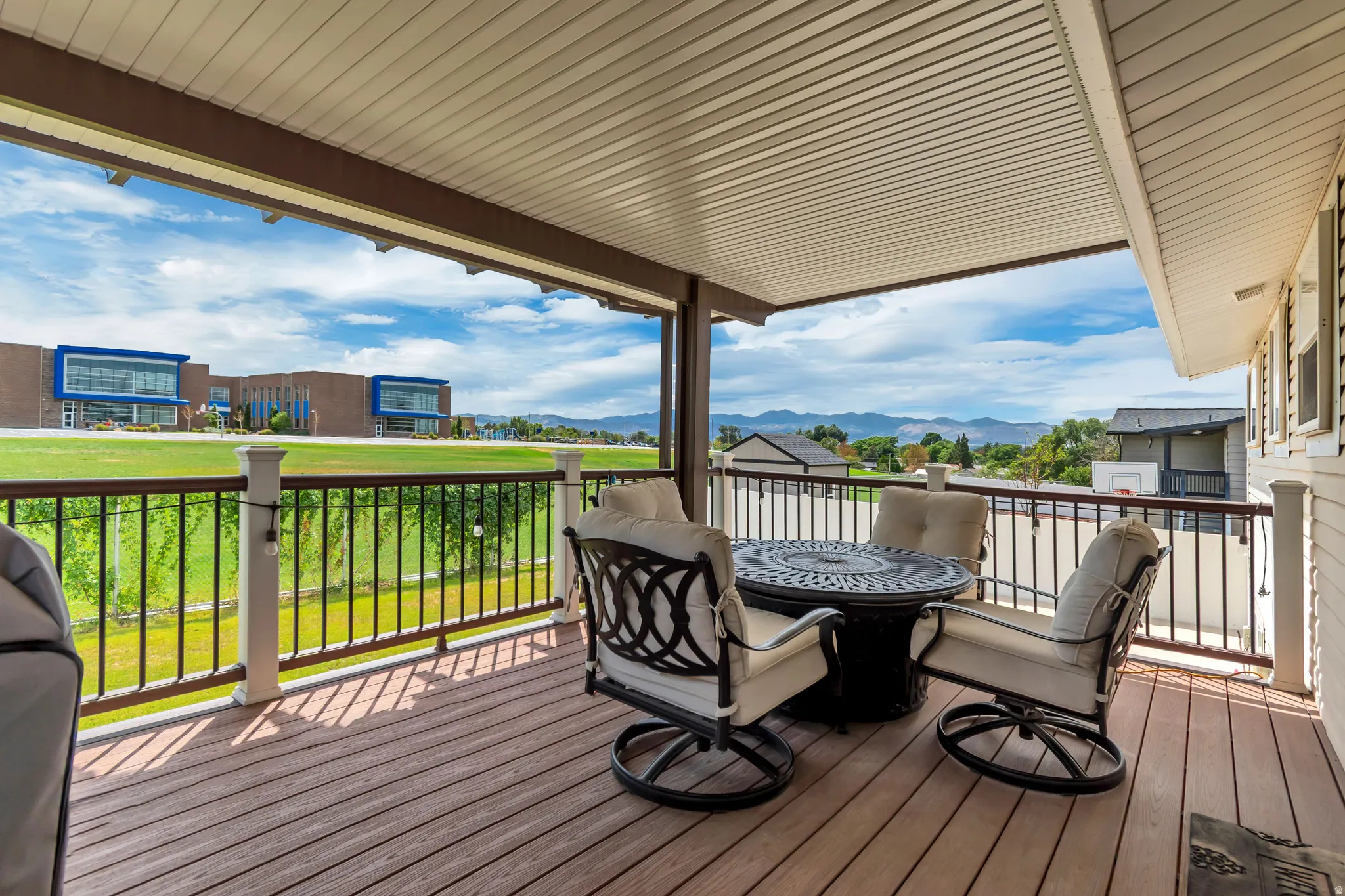 Covered deck featuring composite decking, metal railings, and a solid ceiling
