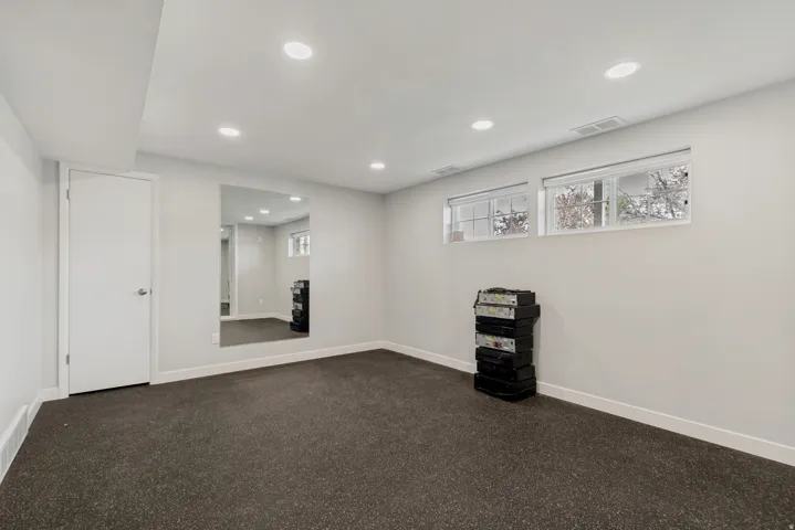 Recessed lighting, large wall mirror, and two windows