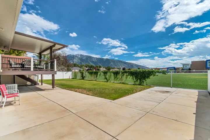 Covered patio featuring a solid roof and wood-tone railing