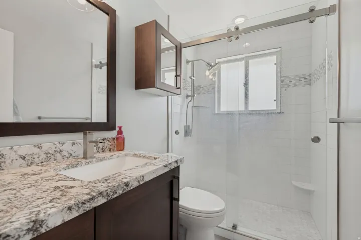 Dark wood-finish vanity with a white rectangular sink and light-toned countertop