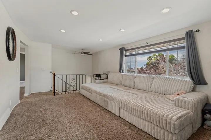 Carpeted room featuring recessed lighting, a ceiling fan, and a large window