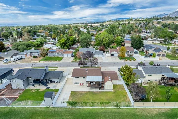 Fenced backyard with a covered deck, detached storage shed, and a concrete patio