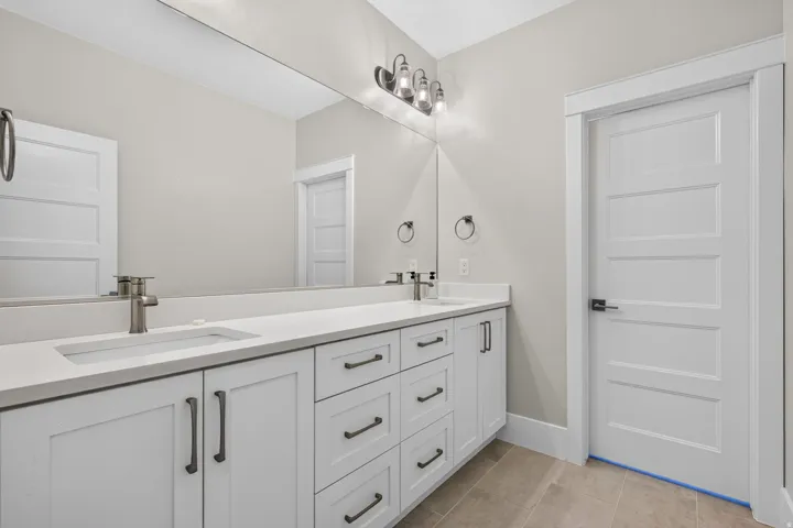 Dual vanity with white cabinetry and dark hardware