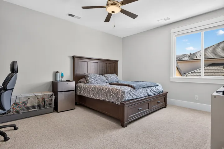 Window with white trim, light gray walls, ceiling fan with integrated lighting, and neutral carpet flooring