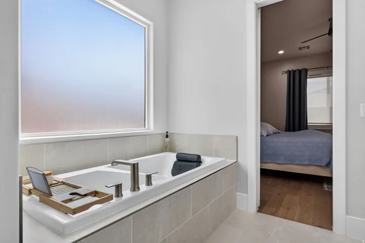 Built-in soaking tub with brushed nickel fixtures and surrounding tile