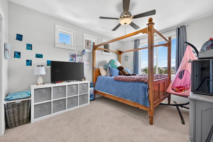 Carpeted room with multiple windows, a ceiling fan with integrated lighting, and light-toned walls