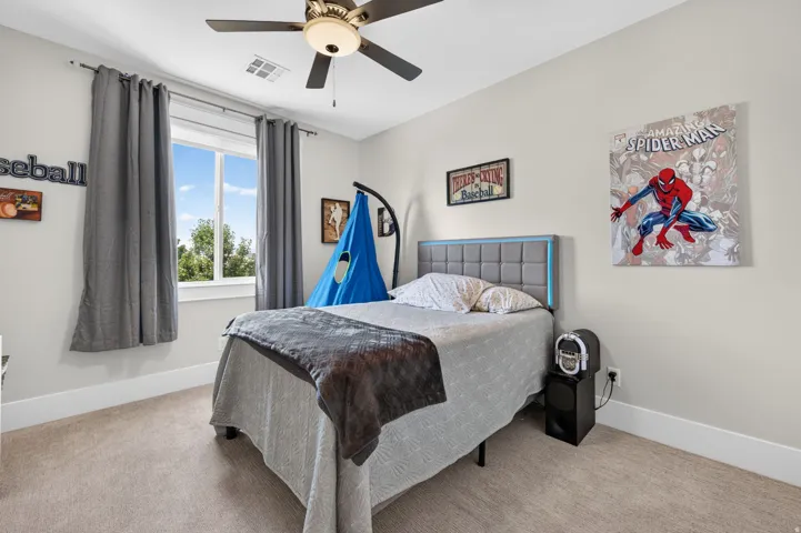 Wall-to-wall carpeting, window with natural lighting, and a ceiling fan with integrated lighting